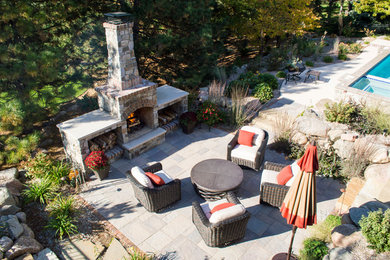 Example of a backyard patio design in Other with a fire pit