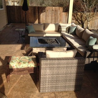 Foto di un patio o portico american style di medie dimensioni e dietro casa con un focolare, cemento stampato e un tetto a sbalzo