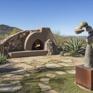 Patio - southwestern stone patio idea in Phoenix with no cover and a fireplace