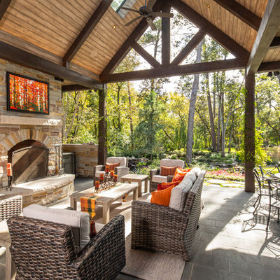 Example of a mountain style backyard patio design in Houston with a fireplace