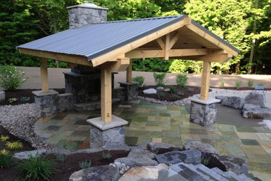 Example of a mid-sized mountain style backyard stone patio kitchen design in New York with a gazebo