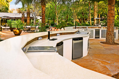 Diseño de patio tropical extra grande sin cubierta en patio trasero con cocina exterior y adoquines de piedra natural
