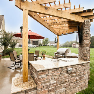 Ispirazione per un patio o portico american style di medie dimensioni e dietro casa con lastre di cemento e una pergola