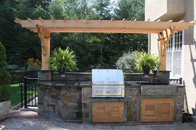 Inspiration for a mid-sized contemporary backyard brick patio kitchen remodel in Philadelphia