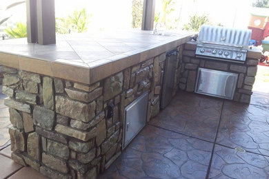 Custom Outdoor Kitchen with Stone Face, Stamped Concrete and Pergola