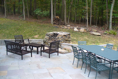 Ejemplo de patio tradicional de tamaño medio sin cubierta en patio trasero con brasero y adoquines de piedra natural