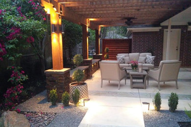 Example of a mid-sized transitional backyard concrete patio design in Houston with a pergola