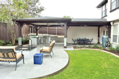 Cette image montre une grande terrasse arrière minimaliste avec une dalle de béton et un gazebo ou pavillon.