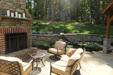 Diseño de patio clásico de tamaño medio en patio trasero con brasero, adoquines de piedra natural y cenador