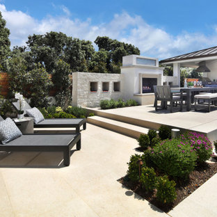 Esempio di un grande patio o portico minimal dietro casa con un caminetto e pavimentazioni in pietra naturale