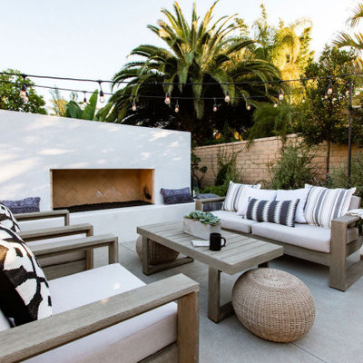 Patio - contemporary concrete patio idea in Orange County with a fireplace and no cover