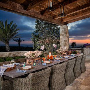Example of a mid-sized tuscan backyard tile patio design in Orange County with a roof extension