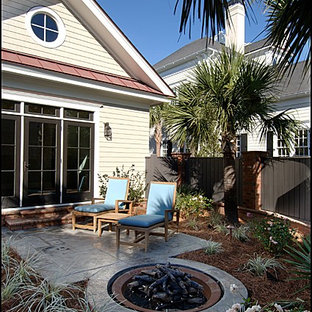 Foto di un patio o portico boho chic di medie dimensioni e dietro casa con un focolare, cemento stampato e nessuna copertura