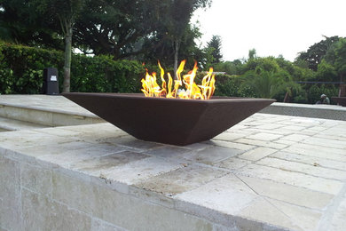 Inspiration for a modern backyard stone patio remodel in Miami with a fire pit
