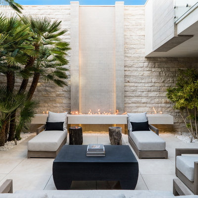 Example of a large trendy courtyard tile patio design in Phoenix with no cover and a fireplace