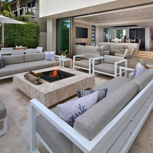 Idee per un patio o portico design con un focolare, graniglia di granito e nessuna copertura