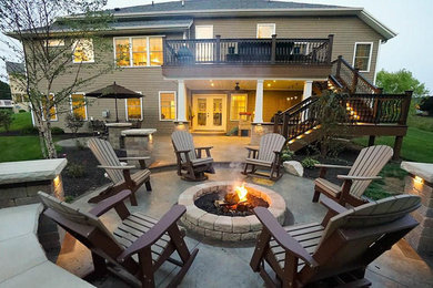 Example of a mid-sized classic backyard concrete patio design in Other with a fire pit and no cover