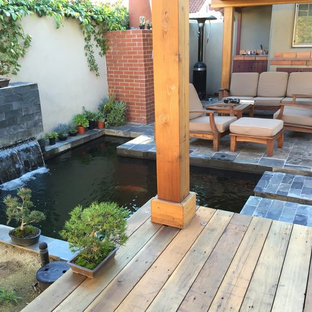 Esempio di un patio o portico etnico di medie dimensioni e dietro casa con fontane, piastrelle e una pergola