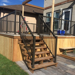 Esempio di un piccolo patio o portico stile americano dietro casa con pedane e nessuna copertura