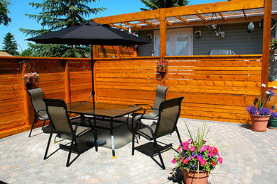 Large classic back patio in Calgary with brick paving, a living wall and no cover.