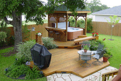 Large trendy backyard patio fountain photo in Austin with decking and a pergola