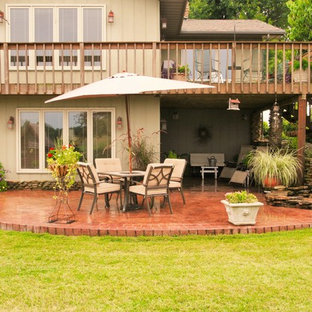 Idee per un grande patio o portico rustico dietro casa con fontane, un tetto a sbalzo e cemento stampato