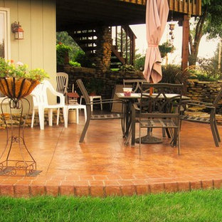 Immagine di un grande patio o portico classico dietro casa con fontane, una pergola e cemento stampato