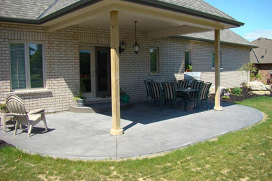 Example of a mid-sized classic backyard concrete patio design in Toronto with a roof extension