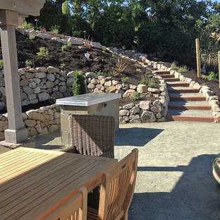 Foto di un ampio patio o portico chic dietro casa con graniglia di granito e una pergola