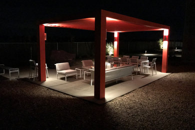 This is an example of a medium sized contemporary back patio in Los Angeles with concrete slabs and a pergola.