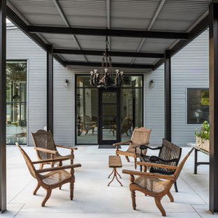 Immagine di un grande patio o portico industriale nel cortile laterale con lastre di cemento