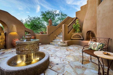 Patio fountain - huge southwestern courtyard stone patio fountain idea in Phoenix with no cover