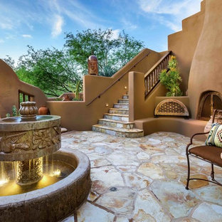Esempio di un ampio patio o portico american style in cortile con fontane, pavimentazioni in pietra naturale e nessuna copertura