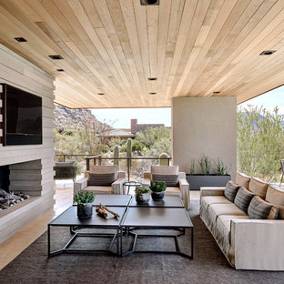 Foto di un grande patio o portico american style dietro casa con un caminetto, un tetto a sbalzo e piastrelle