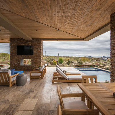 Patio - large contemporary backyard tile patio idea in Phoenix with a roof extension and a fireplace