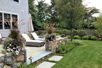 Inspiration for a mid-sized contemporary backyard stone patio remodel in New York with no cover