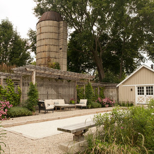 Immagine di un patio o portico country di medie dimensioni e nel cortile laterale con ghiaia e una pergola