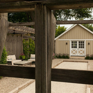 Esempio di un patio o portico country di medie dimensioni e nel cortile laterale con ghiaia e una pergola