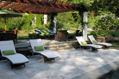 Foto de patio clásico grande en patio trasero con fuente, adoquines de piedra natural y pérgola