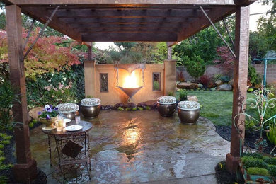 Imagen de patio bohemio de tamaño medio en patio trasero con brasero, adoquines de piedra natural y pérgola