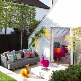 Immagine di un patio o portico bohémian dietro casa con pedane e un parasole