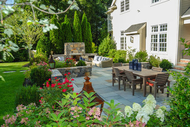 Inspiration for a mid-sized timeless backyard stone patio remodel in Boston with a fire pit