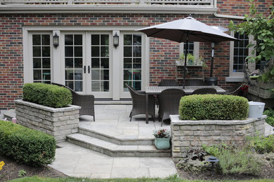 Example of a mid-sized classic backyard stone patio design in Toronto