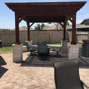 Ispirazione per un grande patio o portico boho chic dietro casa con una pergola e pavimentazioni in mattoni