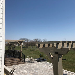 Idee per un ampio patio o portico bohémian dietro casa con un focolare, pavimentazioni in mattoni e una pergola