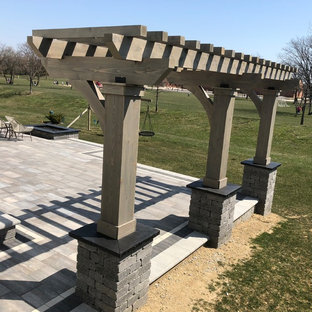 Immagine di un ampio patio o portico bohémian dietro casa con un focolare, pavimentazioni in mattoni e una pergola