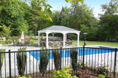 Example of a mid-sized classic backyard stone patio kitchen design in New York with a gazebo