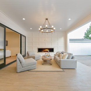 Esempio di un grande patio o portico stile americano dietro casa con un focolare, piastrelle e un tetto a sbalzo