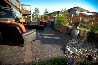 Ejemplo de patio moderno grande sin cubierta en patio trasero con brasero y adoquines de piedra natural