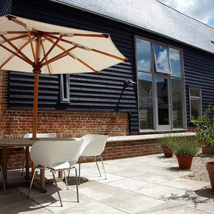 Esempio di un patio o portico boho chic di medie dimensioni e in cortile con pavimentazioni in cemento